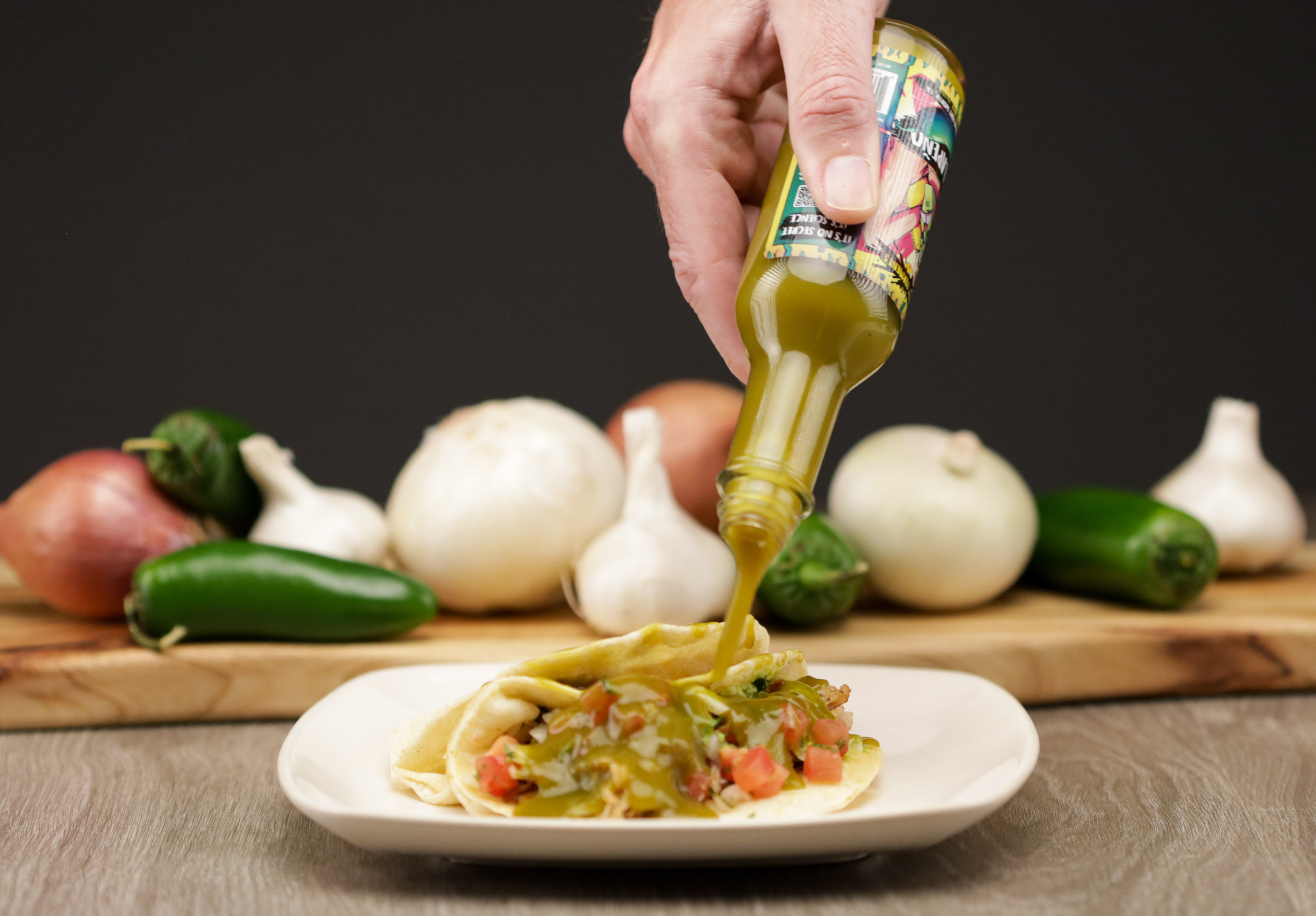 photo of a bottle of jalapeno being poured on food