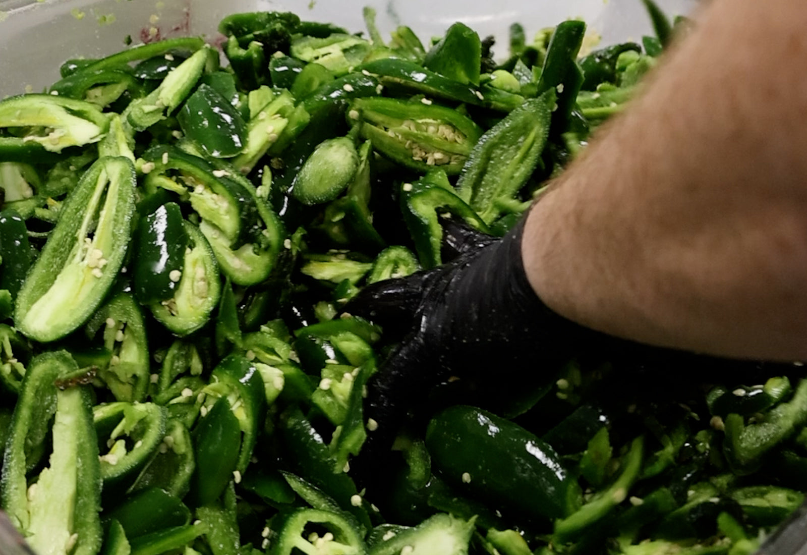 photo of hand massaging jalapeno peppers with salt