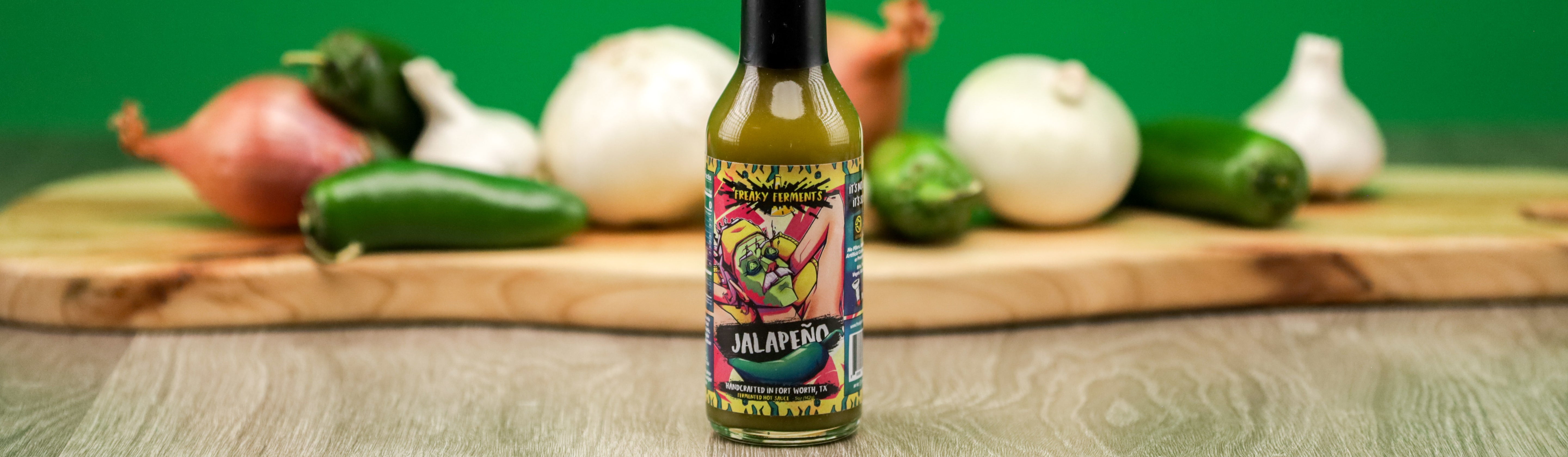 photo of a bottle of jalapeno sauce in front of ingredients